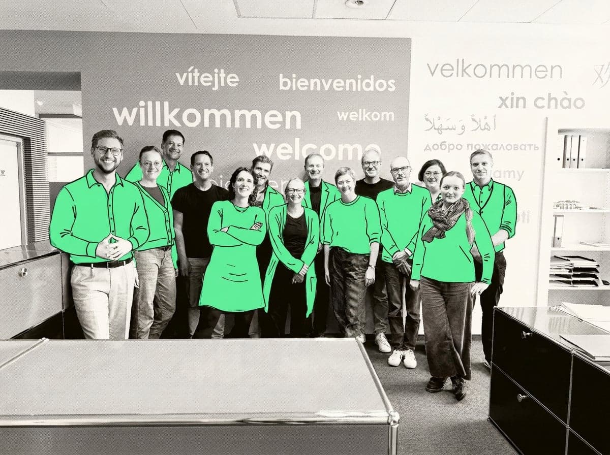 Das Team von Fröbel vor der Willkommen-Wand